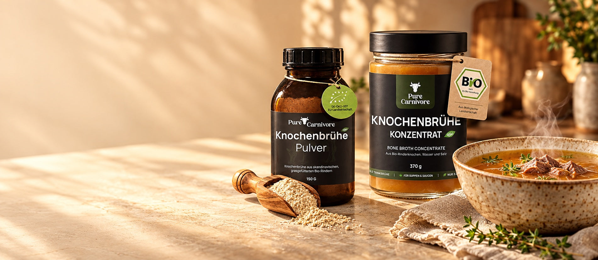 Knochenbrühe-Pulver und Konzentrat mit einer dampfenden Schale Rinderbrühe